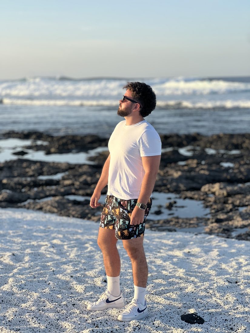 Márk on a white-speckled beach in the Canary Islands, watching the waves