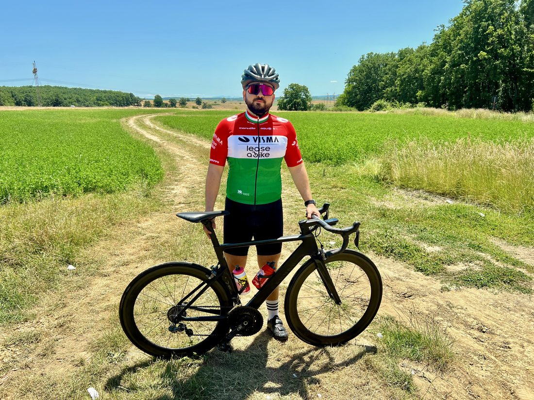 Márk in the Hungarian champion jersey holding his Canyon on a dirt track between fields